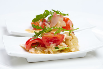 Swedish table appetizers: tomatoes, cheese, arugula, octopus, on