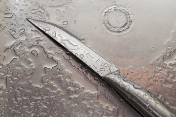 wet the knife on a steel background