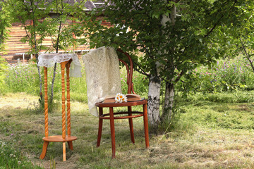 Obraz premium book on a chair in the park with tea and flowers