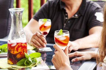 Fototapeta premium Couple drinking white sangria. White sangria with fruits and berry