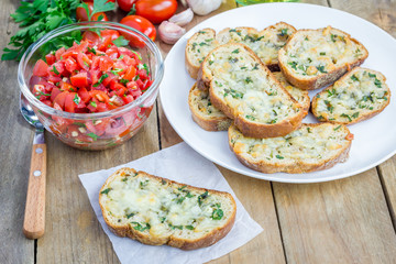 Making tomato bruschetta: garlic cheese crostini and chopped tomatoes with herbs