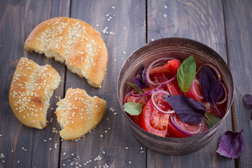 Salad of tomato, red onion, basil and mint with sesame flat brea
