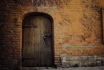 Fototapeta na wymiar Background: old bricks wall and rusty wooden door