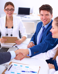 Business people shaking hands, finishing up a meeting, in office
