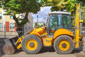 Fototapeta na wymiar Yellow excavator on the street