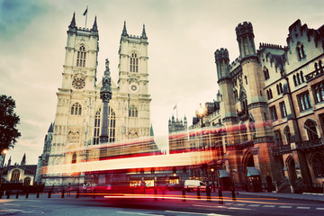 Westminster Abbey church, red bus moving in London UK. Vintage