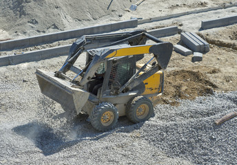 loader small bulldozer moving breakstone at construction area