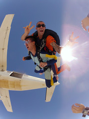 Skydiving tandem jump. The instructor smiled. The student shouts. - 87280494
