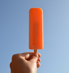 Hand holding fruit juice ice cream.