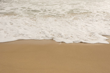 Fototapeta na wymiar Sea wave and many foot print on the beach background