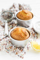 lemon muffins in the baking dish on a light wooden background