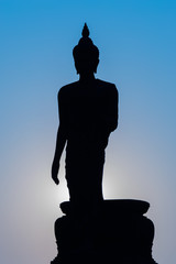 Buddha silhouette statue standing with dark blue background