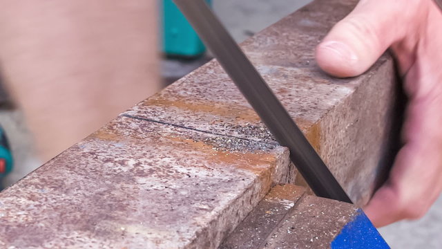 cutting metal workpiece using hand hacksaw 