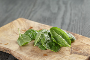 fresh spinach leaves on olive board