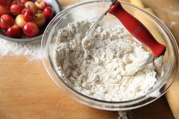 Cutting butter into flour to make pastry crust for cherry pie, copy space included