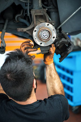 Mechanic working on car brakes