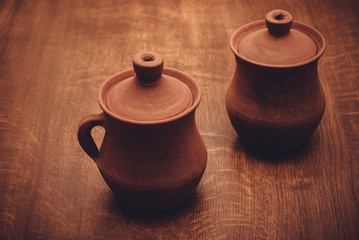 two clay pots on a wooden background