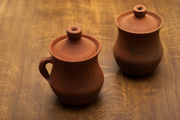 two clay pots on a wooden background