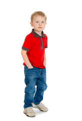 Cheerful little boy in the red sweater and jeans standing 