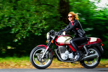 Naklejka na ściany i meble Active girl riding on the motorbike, slow motion, having fun in
