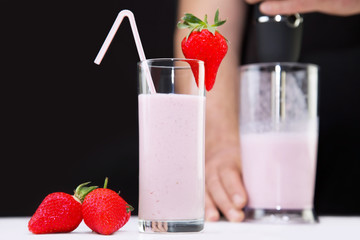 Milkshake with strawberries in glass