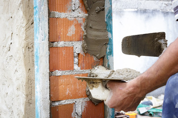 Obreros de la construcción trabajando en obra. Obras en el hogar. Reforma de fachada. Trabajador luciendo la fachada de una casa.