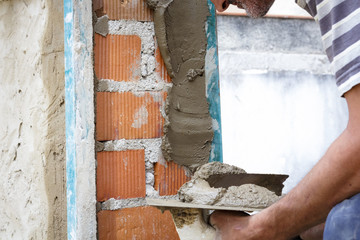 Obreros de la construcción trabajando en obra. Obras en el hogar. Reforma de fachada. Trabajador luciendo la fachada de una casa.