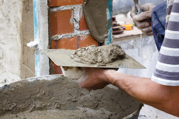 Obreros de la construcción trabajando en obra. Obras en el hogar. Reforma de fachada. Trabajador luciendo la fachada de una casa.