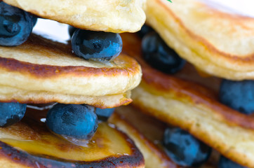 Delicious pancakes close up, with fresh blueberries and maple syrup
