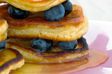 Delicious pancakes close up, with fresh blueberries and maple syrup