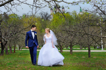 Portrait of bride and groom walking in the spring bloom