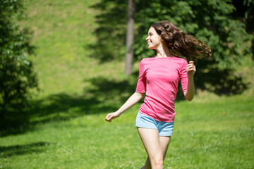 Naklejka na ściany i meble Young beautiful woman running in the park