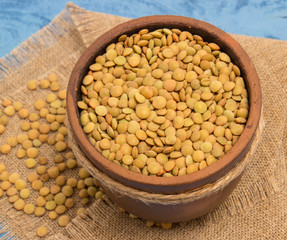 the seeds of green lentils on a blue board