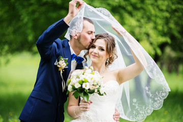 Young lovely and cheerfull wedding couple walking at the park