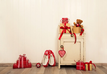 Rustikaler Holz Hintergrund im vintage style mit Geschenken zu Weihnachten in rot weiß kariert.