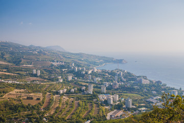 Small town on the Black Sea coast against blue sky with clouds.