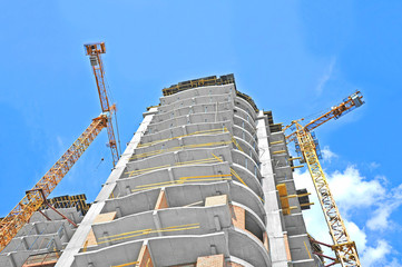 Naklejka premium Crane and building construction site against blue sky