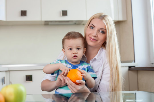 Cheerful young mom is feeding her son