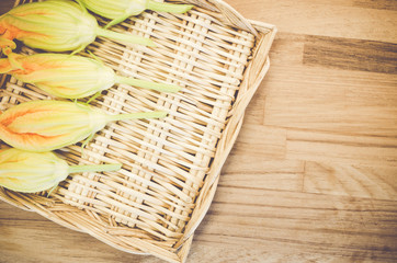 seasonal vegetables - organic zucchini flowers backgrounds in a wicker canister