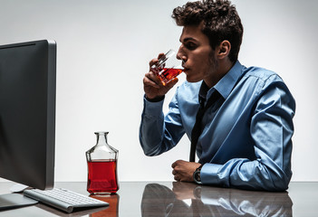 Young drunk caucasian businessman with bottle of alcohol