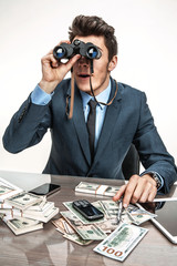 Young businessman looking through binoculars 