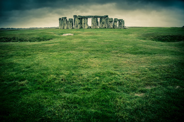 Grass field leading to Stonehenge on a cloudy gray day
