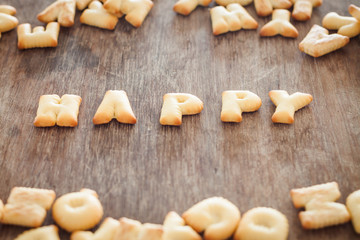 Fototapeta na wymiar Happy alphabet biscuit on wooden table