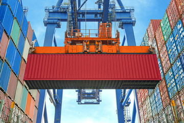 Shore crane loading containers in freight ship - obrazy, fototapety, plakaty