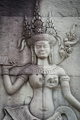 Fototapeta na wymiar Sculptural relief in stone carving of traditional female goddess known as an apsara at Angkor Wat, Cambodia