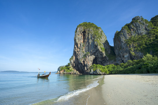 Single longtail boat arriving at scenic morning landscape of Phranang Beach in Railay, Krabi, Thailand