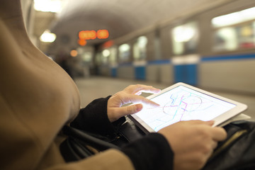 Fototapeta na wymiar Tablet in female hands showing subway map in underground