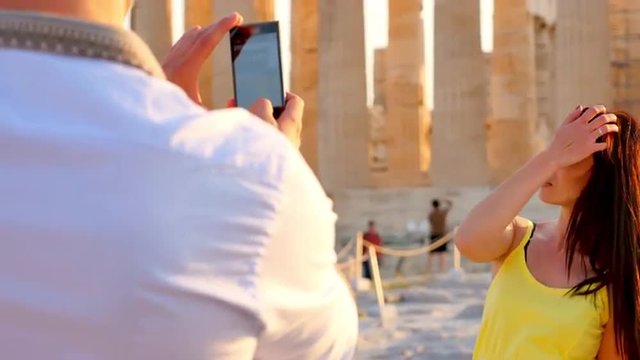 Beautiful Greek woman poses for a photo in front of a Greek temple.