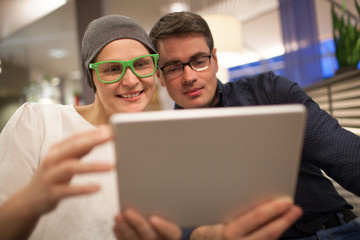 Man and woman using electronic tablet in the restaurant
