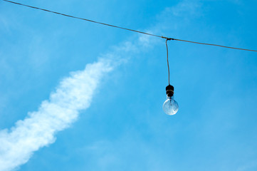 One light bulb on a wire with sky 